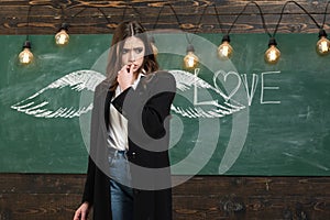 School wings and dream. School lessons. Young attractive teacher pointing at chalkboard. Back to school and happy time