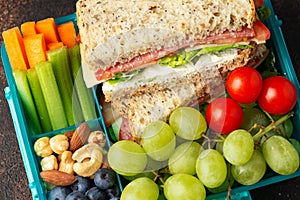 School, work lunch box with sandwiches and fresh vegetables, nuts and fruits. Healthy food.