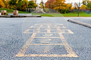 School and schoolyard with hopscotch and playground for elementary students in evening in fall season