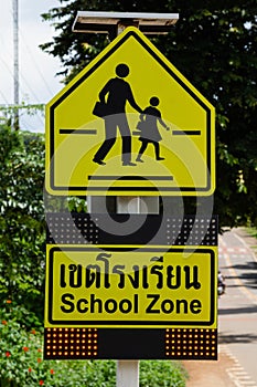 School zone sign on tree and road background  Traffic sign.