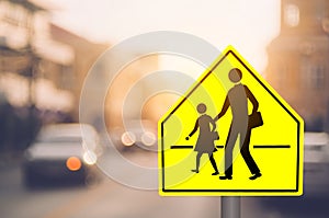School zone warning sign on blur traffic road with colorful bokeh light abstract background