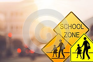 School zone warning sign on blur traffic road with colorful bokeh light abstract background