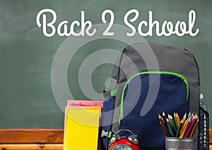 Schoolbag on Desk foreground with blackboard graphics of Back 2 School
