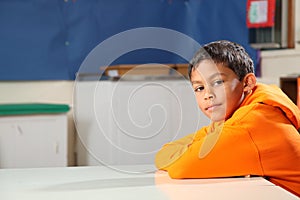 Schoolboy 10 arms folded deep in thought classroom