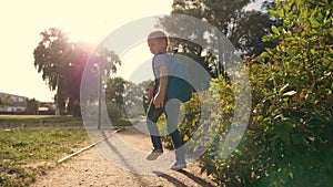 A schoolboy with a backpack and a book in the Park. A happy child runs to school on the road. The boy is in a hurry for