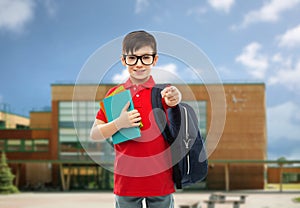 Schoolboy with books and bag over school