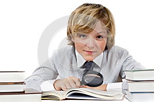 Schoolboy with books and magnifying glass