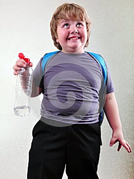 Schoolboy with a bottle of water making faces