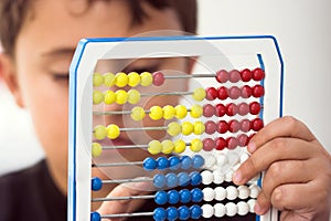 Schoolboy calculate with abacus