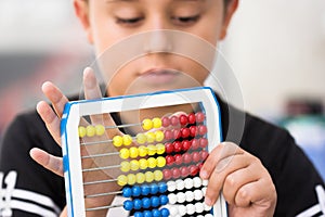 Schoolboy calculate with abacus