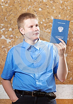 Schoolboy with the certificate about completion of education at school