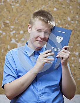 Schoolboy with the certificate about completion of education at school