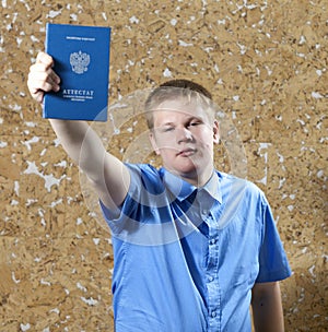 Schoolboy with the certificate about completion of education at school