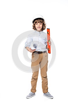schoolboy in costume of architect and helmet holding blueprints and bubble level