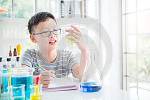 Schoolboy doing chemistry experiment in laboratory classroom. Education concept
