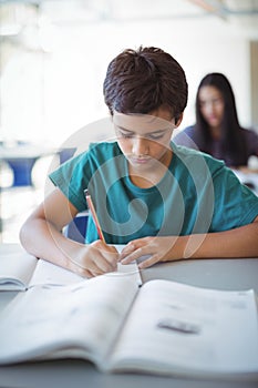 Schoolboy doing homework in classroom