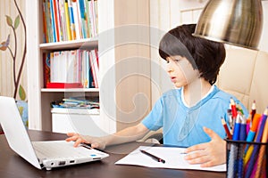 Schoolboy doing homework in room photo