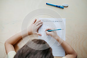 A schoolboy doing math lesson sitting at desk in the children room