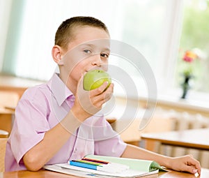 Schoolboy eating an apple