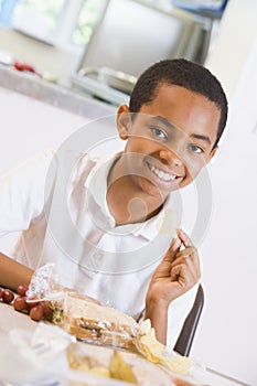 Schoolboy enjoying his lunch in a school cafeteria