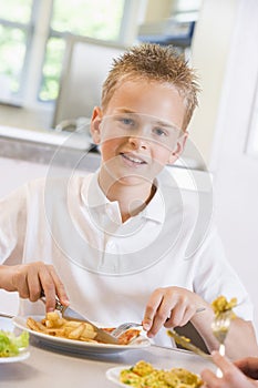 Schoolboy enjoying his lunch in a school cafeteria