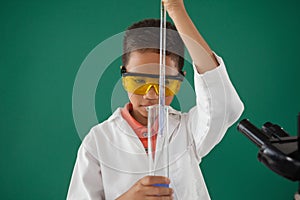 Schoolboy experimenting against green background