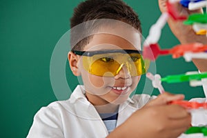 Schoolboy experimenting molecule model in laboratory