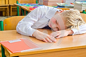 A schoolboy fell a sleep on a lesson. photo