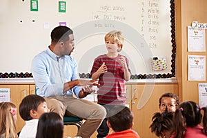 Schoolboy at the front of elementary class with teacher