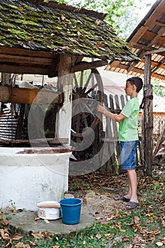 Schoolboy getting water from well