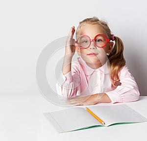 A schoolgirl with glasses at a table