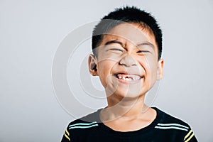 Schoolboy grins upper tooth lost gap shown in smile. Child dental care isolated