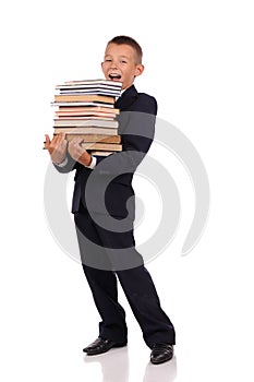 Schoolboy holding huge stack of books