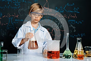 Schoolboy in laboratory wear lab coat learning science of chemistry. Erudition.