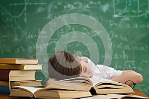 Schoolboy lying and sleeping on book