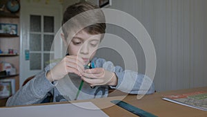 Schoolboy make homework and using drawing compass and ruler to draw a car