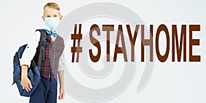 A schoolboy with a medical mask on his face is holding a school backpack, next to it is written the text - STAYHOME