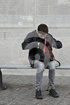 Schoolboy rummages in his rucksack, checking his books