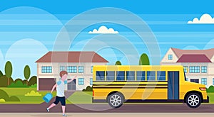 Schoolboy running to chase yellow school bus pupils transport concept residential suburban street landscape background