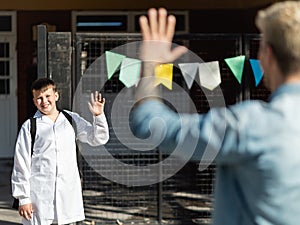 Schoolboy saying goodbye to his father at the entrance of school in Argentina