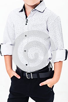 Schoolboy in a school uniform on a white background. Boy demonstrating shirt with rolled up sleeves