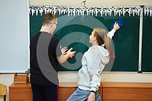 A schoolboy and a schoolgirl at the blackboard.