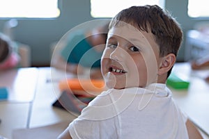 Schoolboy sitting at a desk in an elementary school classroom