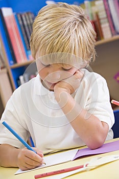 A schoolboy sitting in a primary class