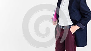 A schoolboy stands on a white background in a school uniform - trousers, a jacket and a shirt. A boy holding a textbook