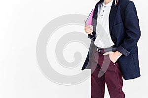 A schoolboy stands on a white background in a school uniform - trousers, a jacket and a shirt. A boy holding a textbook