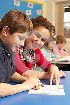 Schoolboy Studying In Classroom With Teacher