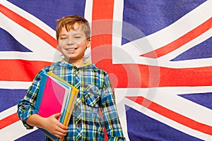 Schoolboy with textbooks against English flag