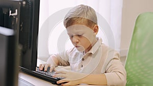 Schoolboy using computer in a class