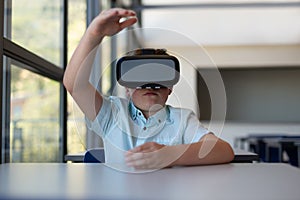 Schoolboy using virtual reality headset in a classroom